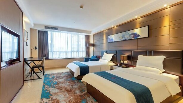 A hotel room with two beds, a desk, and a large window. - Wind bell Hotel (Foshan Guicheng Metro Station) (Foshan)