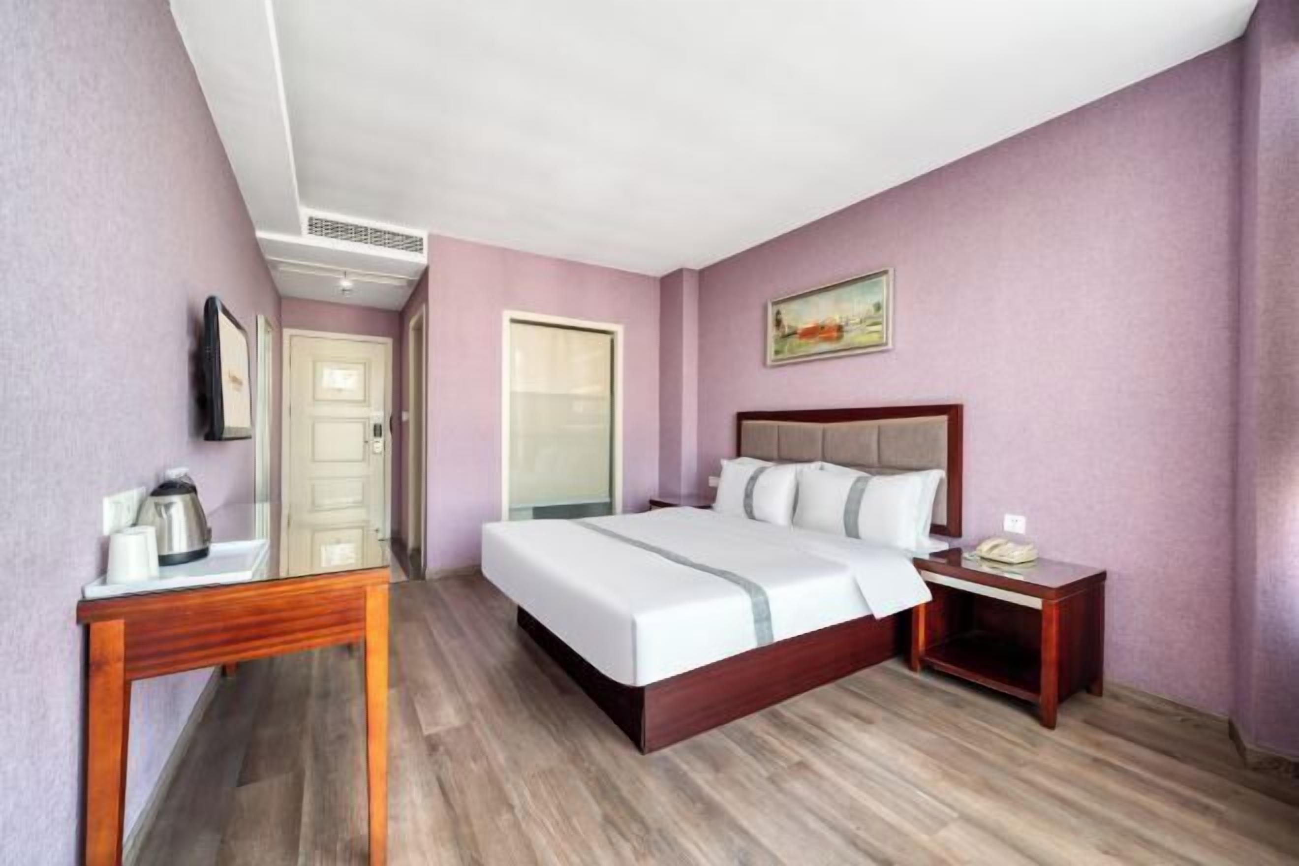 Ein Hotelzimmer mit Bett, Nachttisch und einem kleinen Tisch mit Wasserkocher.