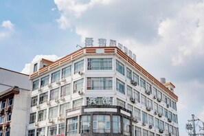 A multi-story hotel with a modern architectural design, featuring a prominent corner entrance and a series of balconies. - A·K·S Fashion Hotel (Wenzhou)