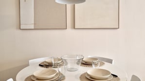 A round dining table with white chairs, a hanging pendant light, and framed artwork on the wall. - SR Dunas de Carib Playa Marbella (Marbella)