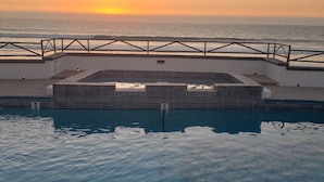 A pool with a view of the sunset over the ocean. - Spectacular oceanview penthouse - rooftop terrace, bbq, pool, jacuzzi & beach (Primo Tapia)