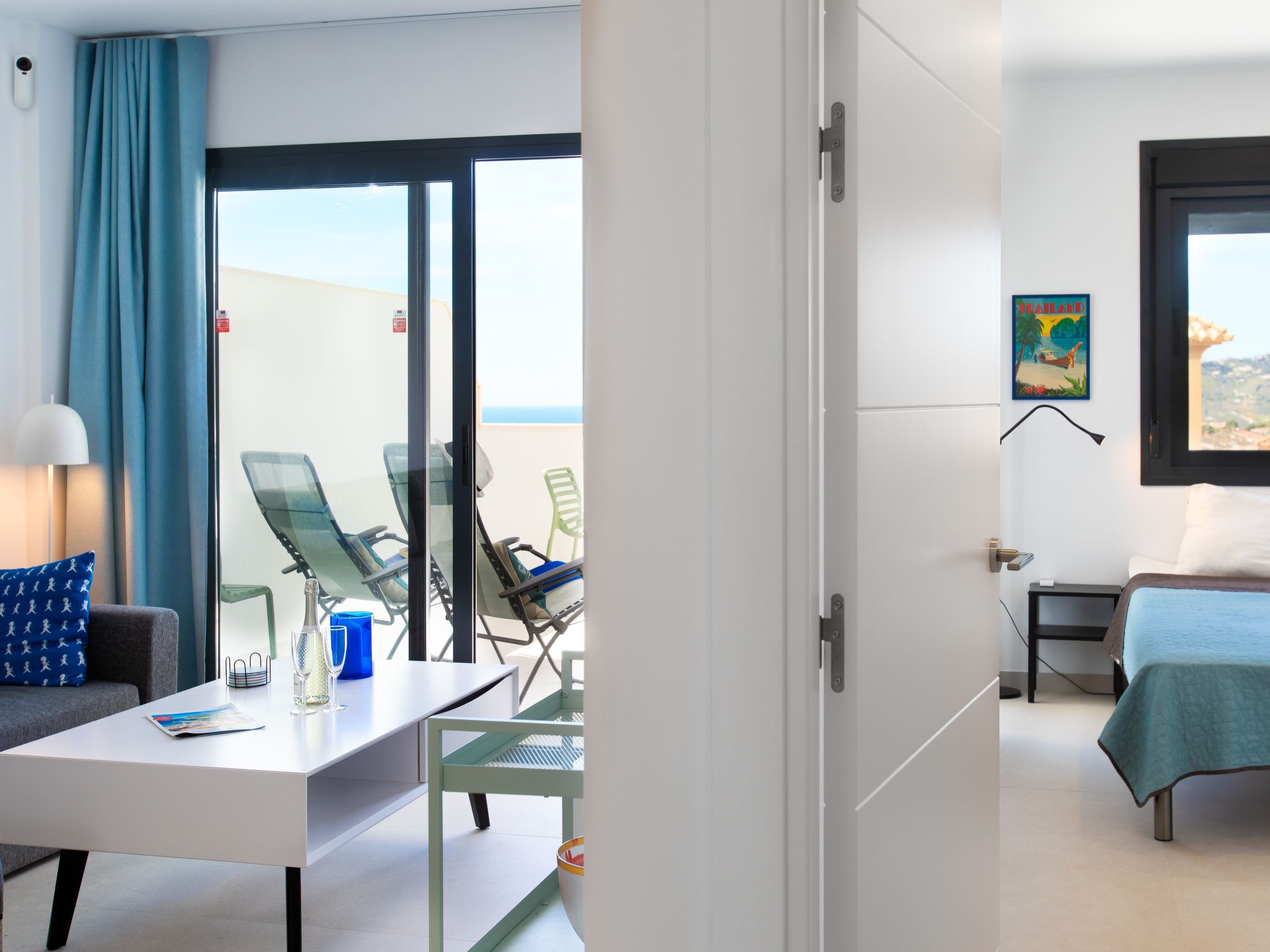 Ein Hotelzimmer mit Balkon, einem Bett, einem Schreibtisch und einem Stuhl.