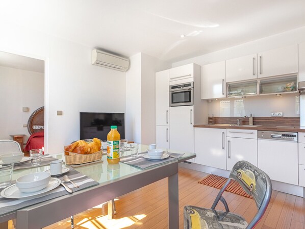 A modern kitchen with white cabinets, a Bosch dishwasher, and a microwave. - Boulevard Louis Blanc by Interhome (Saint-Tropez)