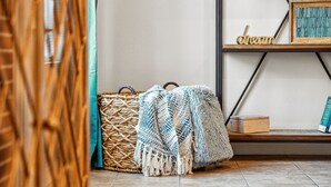 A room with a woven basket, a crocheted blanket, and a shelf with a framed picture and the word "dream".
