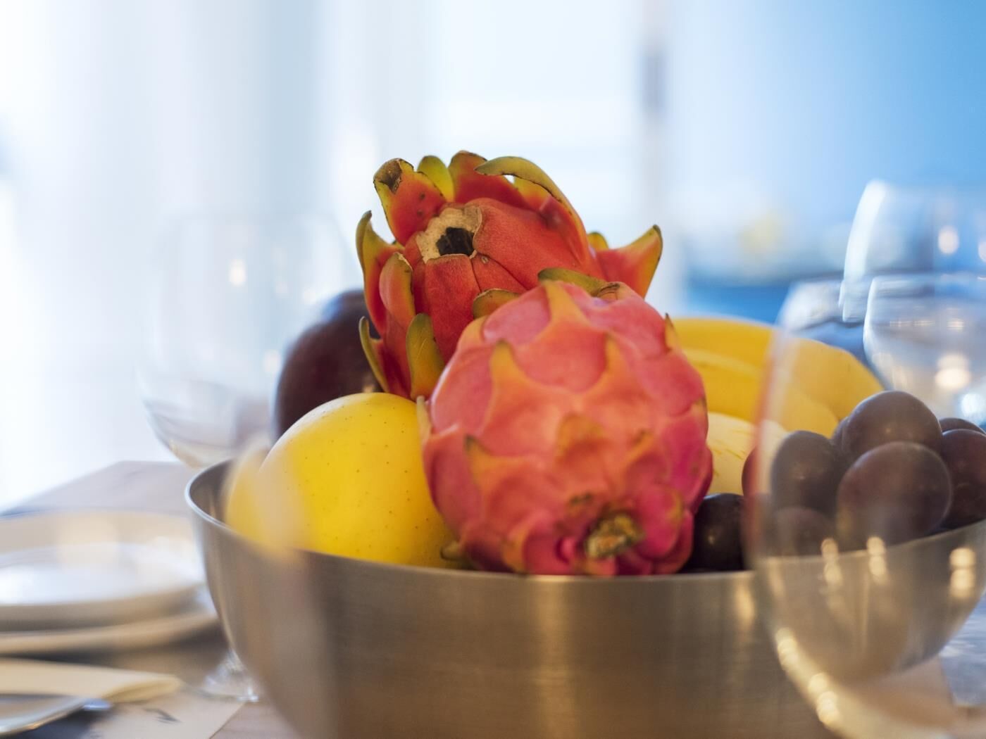 Un bol amb fruita, incloent pitahaya, mango i raïm.