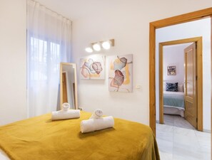 Ein Schlafzimmer mit Bett, Spiegel und Bildern an der Wand.
