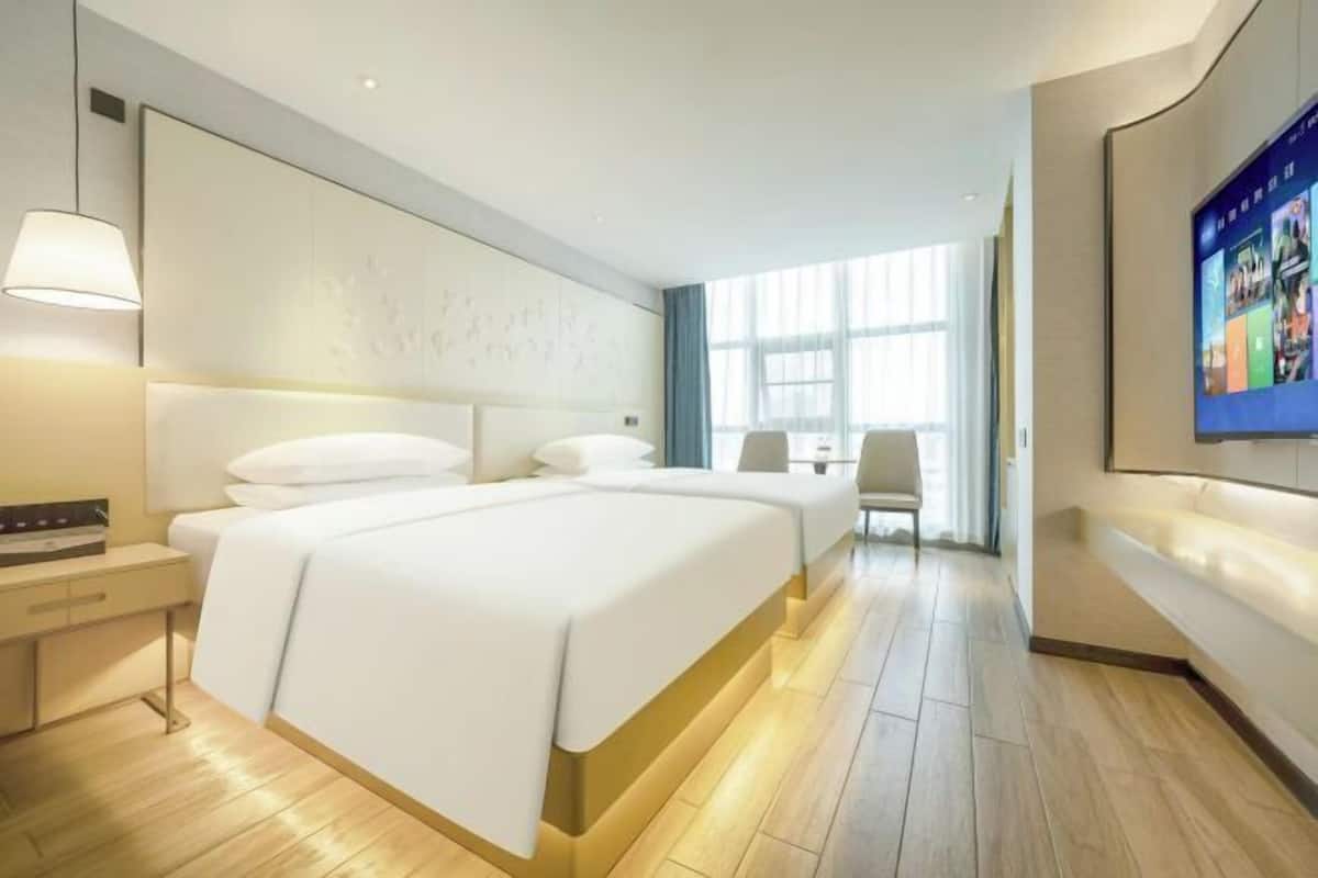 Een hotelkamer met een groot bed, nachtkastjes, een bureau en een televisie.