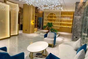 Um interior moderno com um sofá branco, uma mesa redonda e um lustre decorativo.