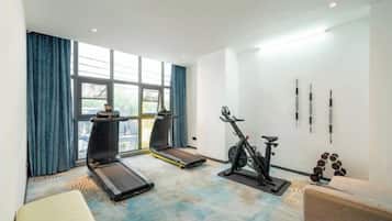 Habitación de hotel con una caminadora, bicicleta estática y equipo de ejercicio.