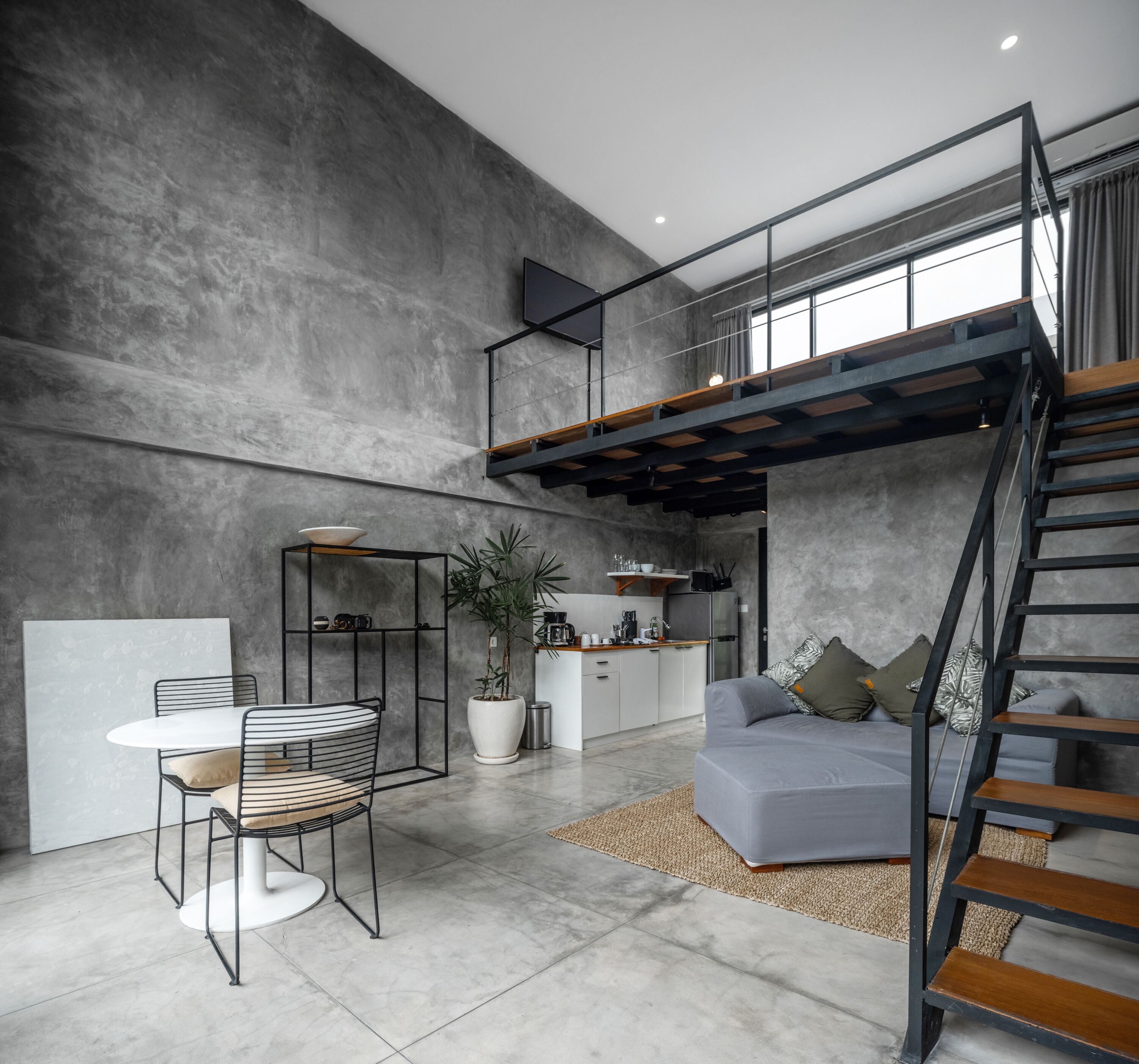 Un espace de vie moderne de style loft, comprenant une mezzanine, un coin repas et une cuisine.