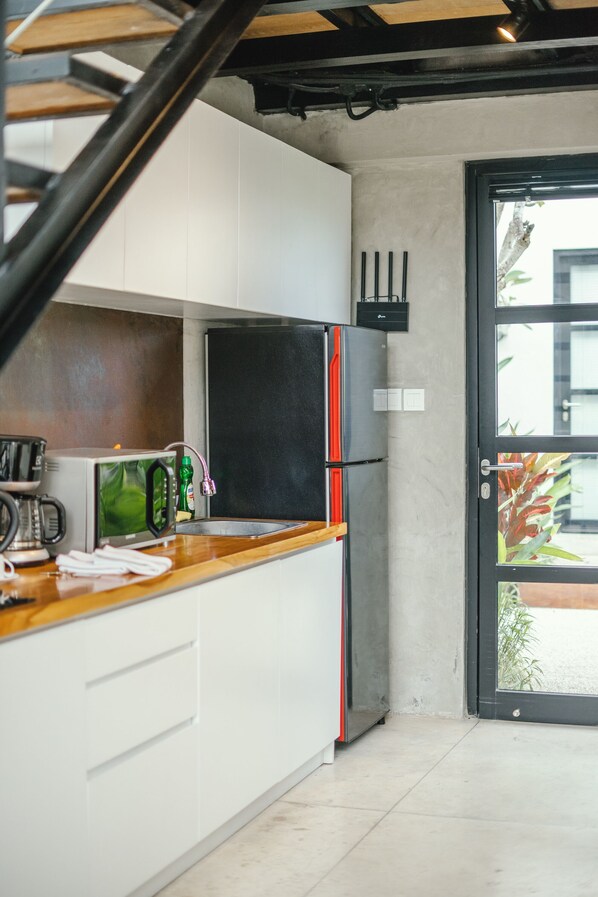 A modern kitchen with white cabinets, a stainless steel refrigerator, and a wooden countertop. - Canggu 2Plex (Canggu)