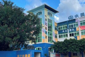 A multi-story building with signage indicating a hotel and a restaurant. - Green Island Yacht Hotel (Shanwei)