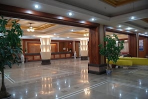 A spacious lobby with a polished floor, large columns, and a reception desk. - Green Island Yacht Hotel (Shanwei)