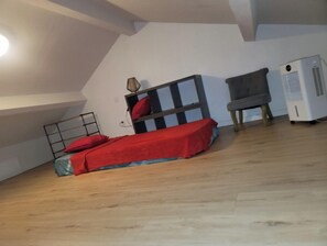 Cozy retreat with a bed, table, and chair, offering a simple and functional space.