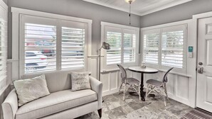 A room with a white sofa, a table with two chairs, and a ceiling fan. - Good Vibrations - Beach House (Treasure Island)