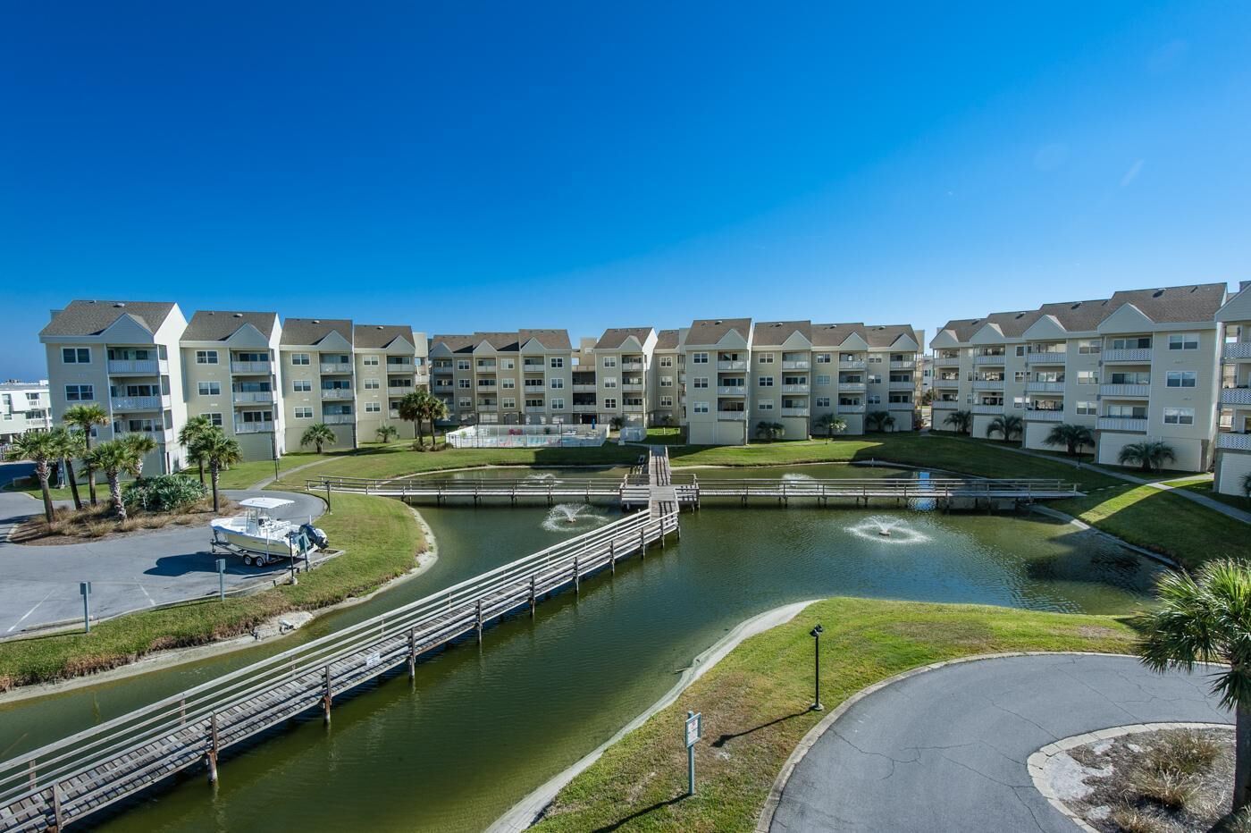 Un complejo residencial con varios edificios de apartamentos, una fuente central y un embarcadero.