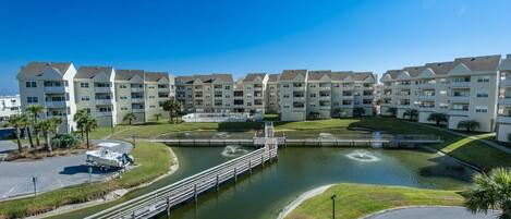 Un complejo residencial con varios edificios de apartamentos, una fuente central y un embarcadero.