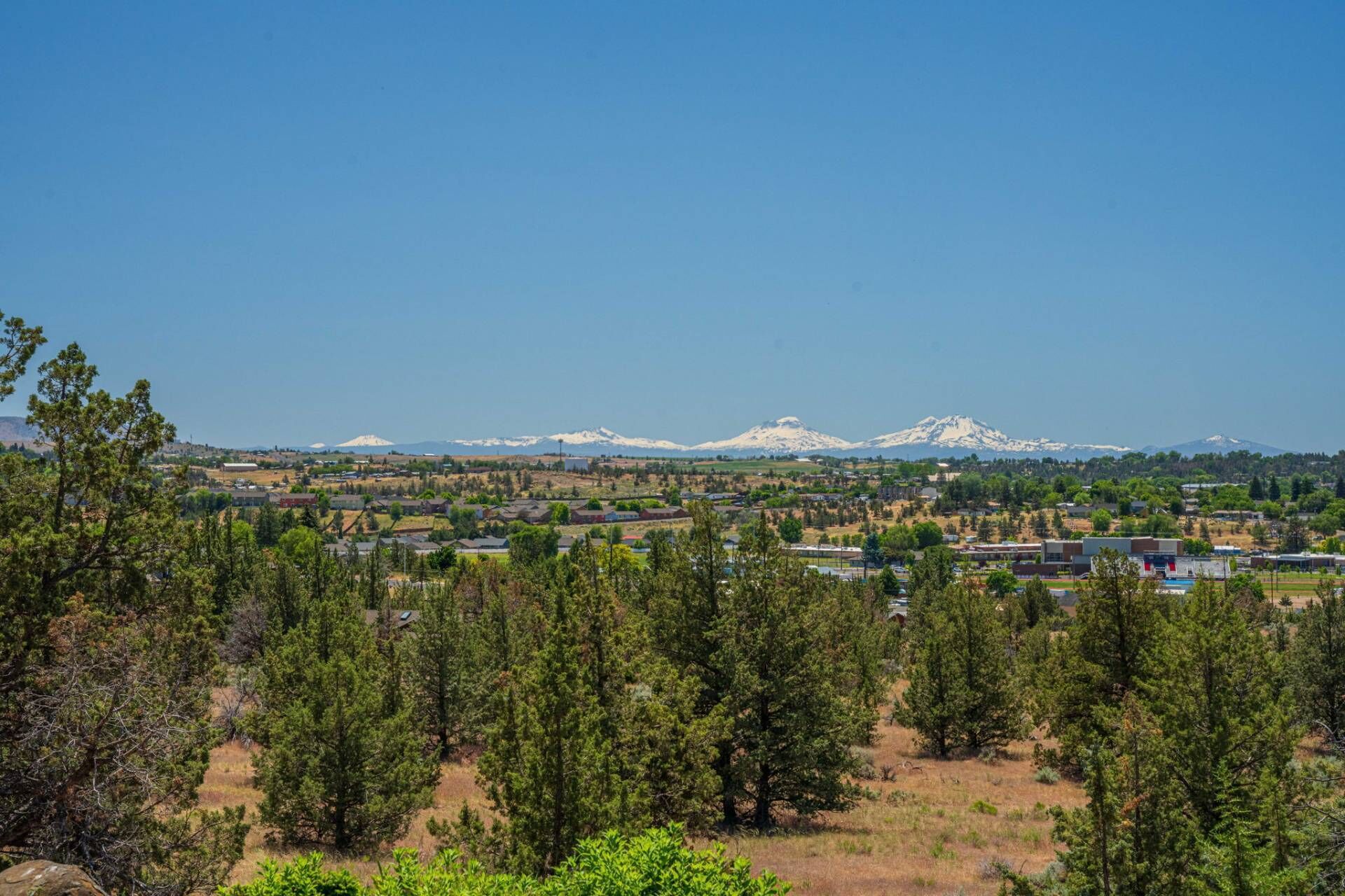 A town with a mountain range in the background, surrounded by dense forests.