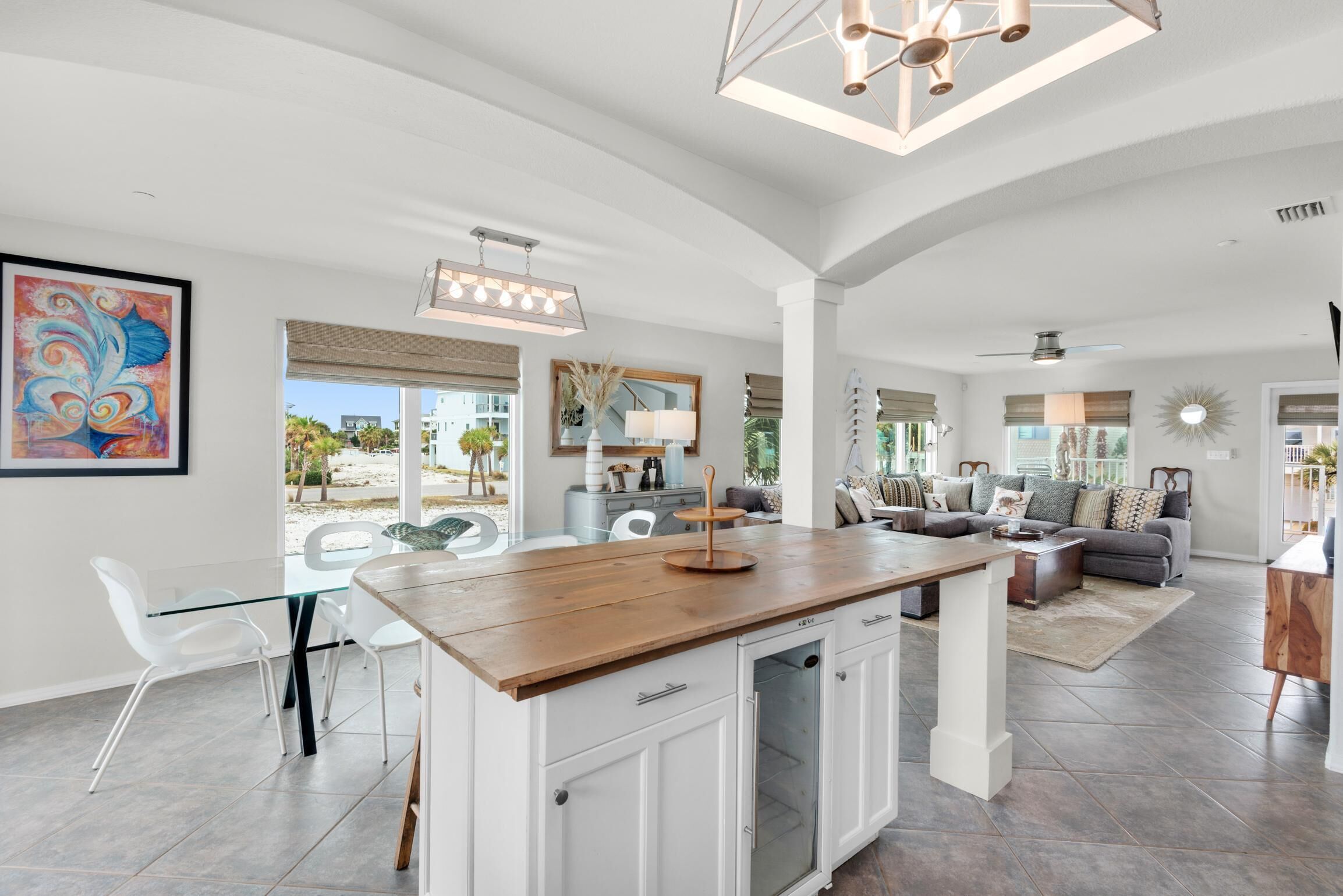 A spacious living area with a kitchen island, dining table, and seating.