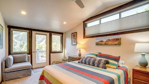 A bedroom with a large bed, a chair, a nightstand, and a window with blinds. - Hike, Soak & Play: Keystone Home w/ Views! (Keystone)