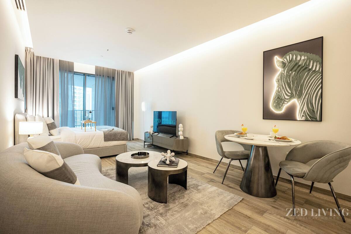 A modern living room with a sofa, coffee table, and dining area.