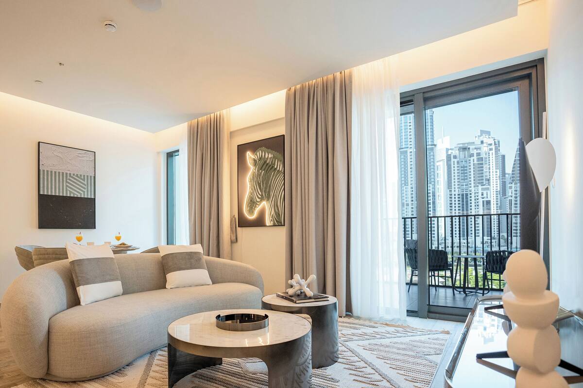 A modern living room with a sofa, coffee table, and artwork on the walls.