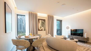 A modern living room with a dining area, a large window with a city view, a mounted zebra artwork, and a flat-screen TV on a stand. - Ahad Residences (Dubai)