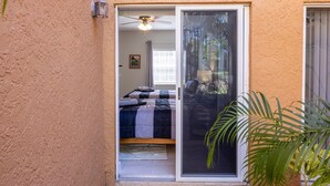 A small, enclosed patio area with a sliding glass door leading to a bedroom. - Studio at the PGA (Port St. Lucie)