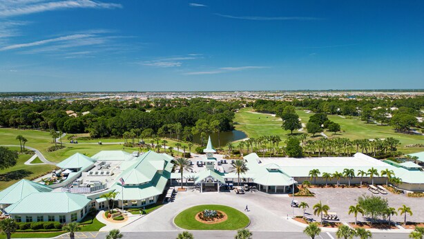 A large, modern building with a green roof, surrounded by lush greenery and a golf course. - Studio at the PGA (Port St. Lucie)