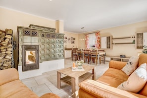A living room with a fireplace, a dining area, and a sofa.