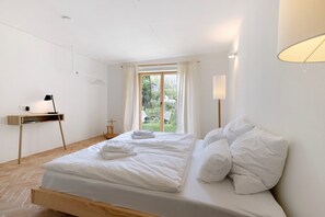 Una camera da letto con un letto, un comodino, una lampada e vista sull'esterno.