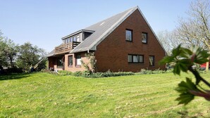 A brick house with a sloped roof and a small balcony. - Apartment 'Hoern 1' with Wi-Fi (Nordstrand)