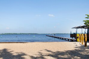 A beach with a wooden pier extending into calm water, a sandy shore, and a small structure with a roof. - Smolly's Ferienwohnung with Private Terrace, Garden & Wi-Fi (Bad Zwischenahn)