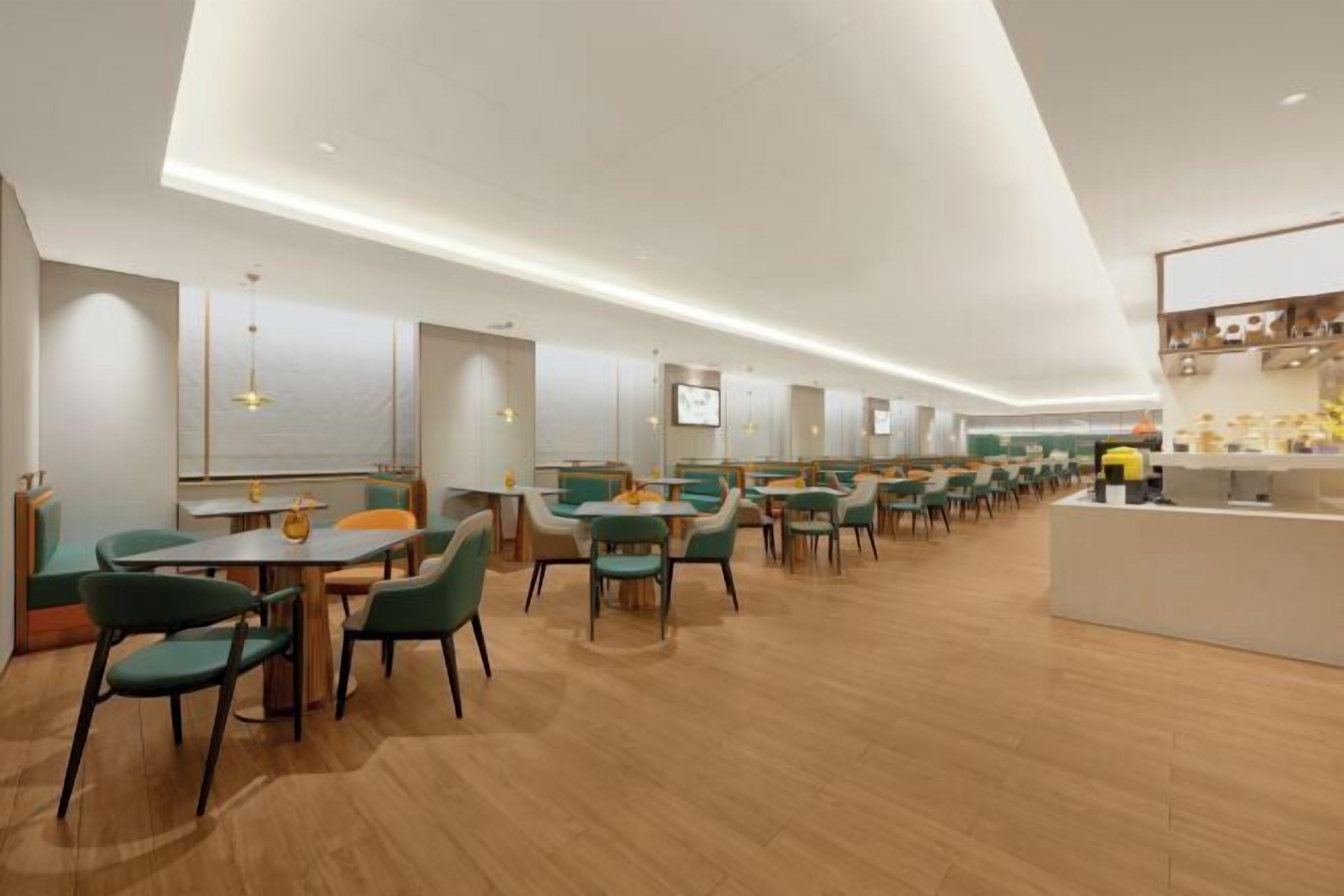 A modern dining area with multiple tables and chairs, a counter, and a ceiling with recessed lighting.