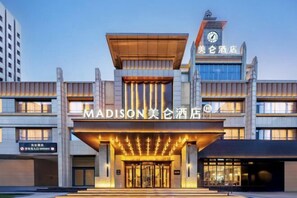 A modern hotel with a prominent entrance, a clock tower, and signage in both English and Chinese. - Madison Hotel Taiyuan Shanxi Museum University of Technology (Taiyuan)