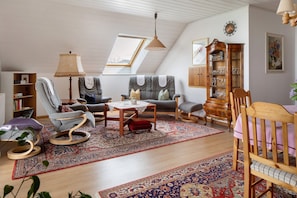 Quarto estilo loft com claraboia, um armário de madeira e um espaço de refeições.
