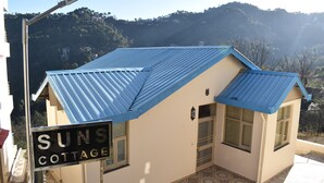 A small building with a blue roof and a sign that reads "SUNS COTTAGE." - SUNS Cottage (Kasauli)