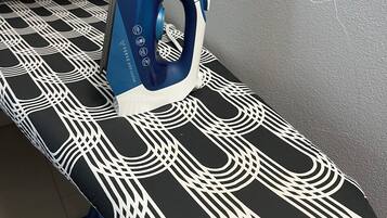 An ironing board with a patterned cloth and an iron.