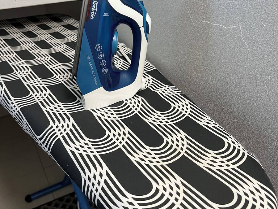 An ironing board with a patterned cloth and an iron.