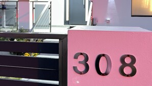 Un edificio moderno con una cassetta delle lettere rosa con il numero 308.