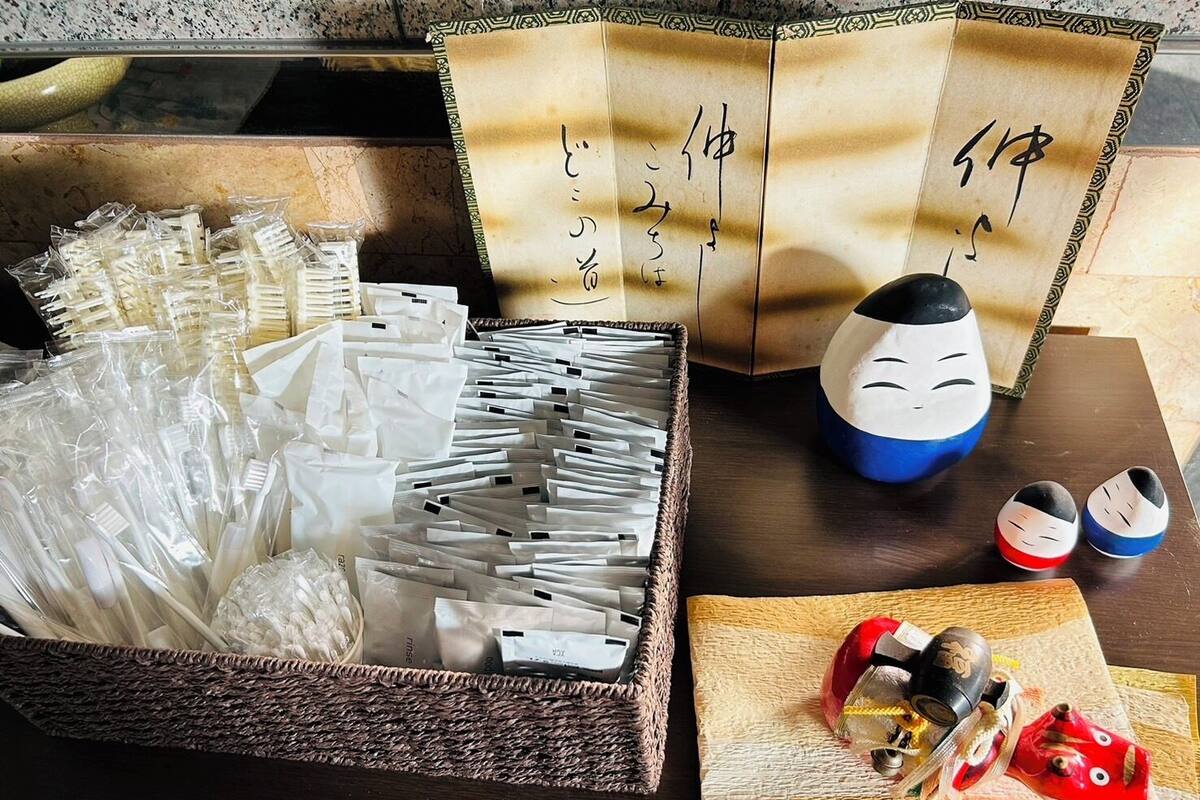 Dispositiu tradicional de cerimònia del te japonesa amb una taula de fusta, una cistella teixida de bacinals blancs, un parell de bacinals de fusta i un conjunt decoratiu per al te.