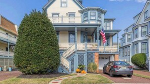 Une maison à deux étages avec un balcon, un garage et une allée menant à un emplacement de stationnement.