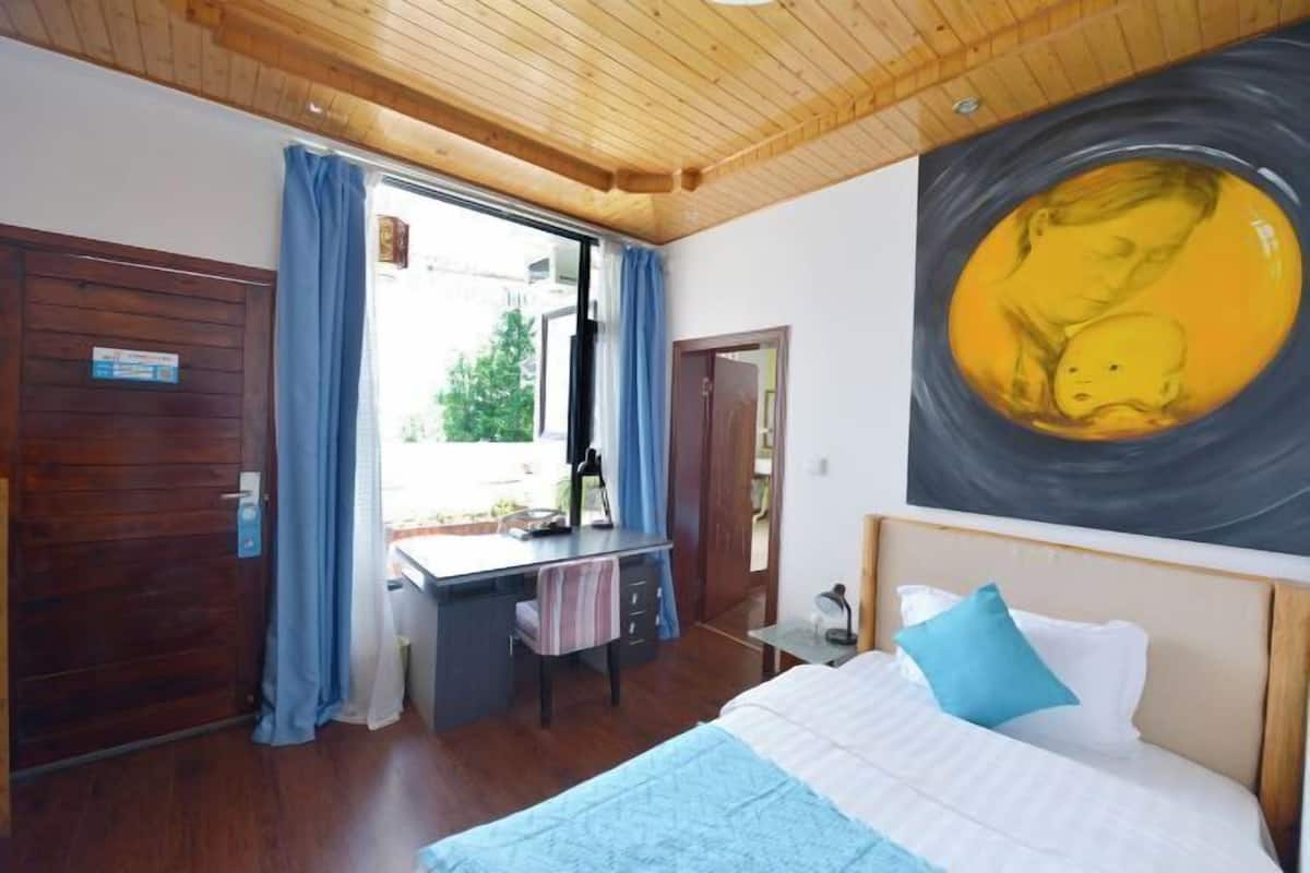 Une chambre à coucher avec un lit, un bureau et un tableau.