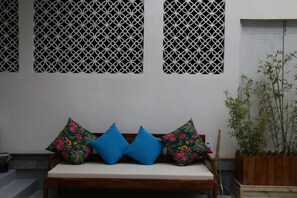 A bench with cushions, a wooden planter with plants, and a decorative wall panel. - Erhaike Inn (Dali City)