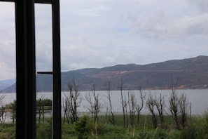 A view through a window of a lake with mountains in the background. - Erhaike Inn (Dali City)