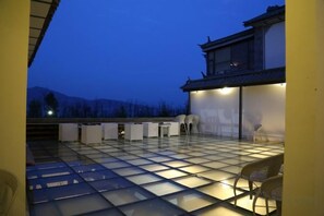 A rooftop terrace with a tiled floor, seating area, and a building with traditional architecture. - Erhaike Inn (Dali City)