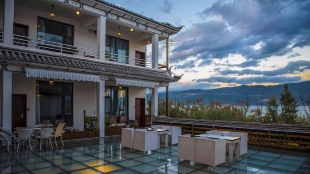 Un edificio moderno con un estilo arquitectónico tradicional, que cuenta con un balcón con asientos y vistas a las montañas.