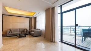 Una sala de estar moderna con un sofá, una mesa de centro y vistas a un balcón con mobiliario exterior.