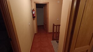 A narrow hallway with wooden doors and a red carpet. - Casa Rural Abuela Maria (Pasarón de la Vera)