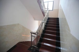 A staircase with a metal railing, leading upwards.